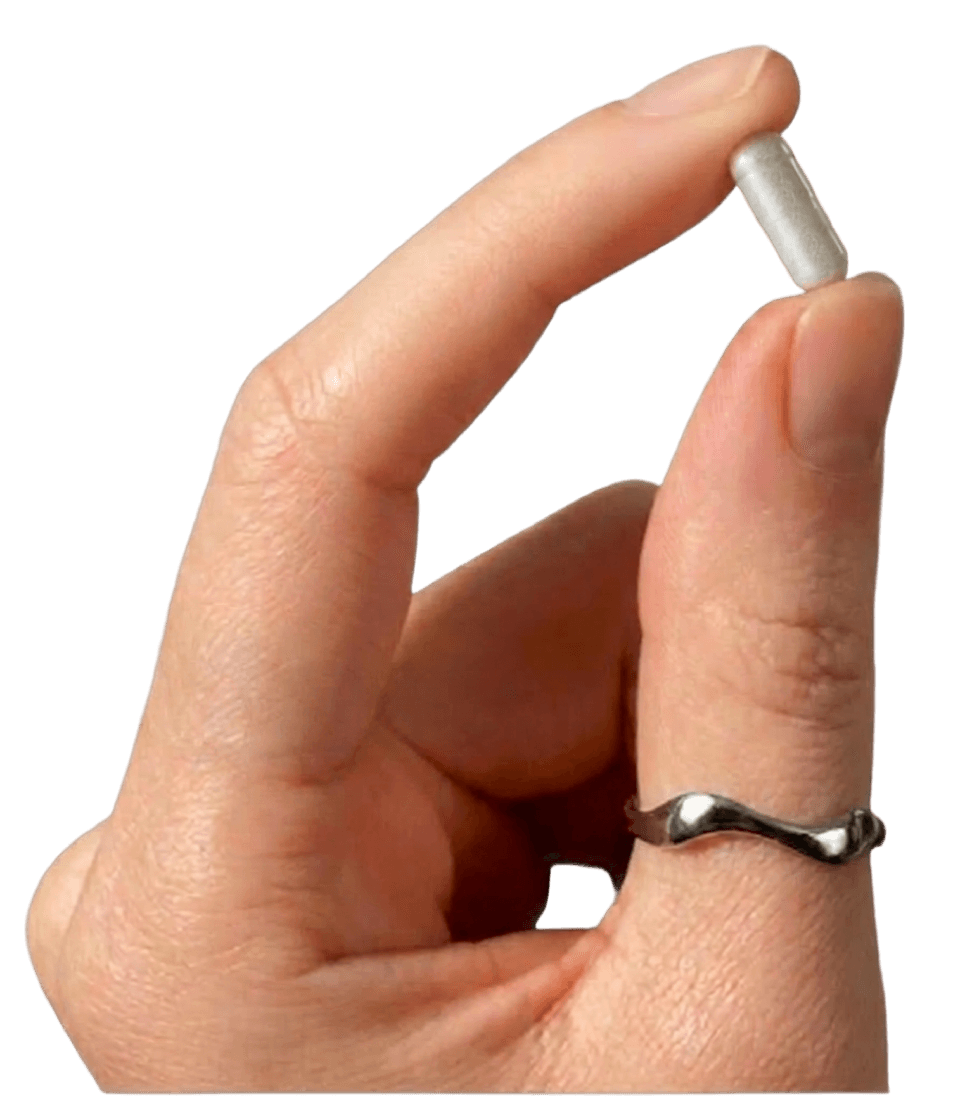 Hand holding a Norethisterone tablet