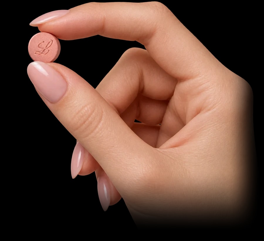 Hand holding a daily weight loss tablet